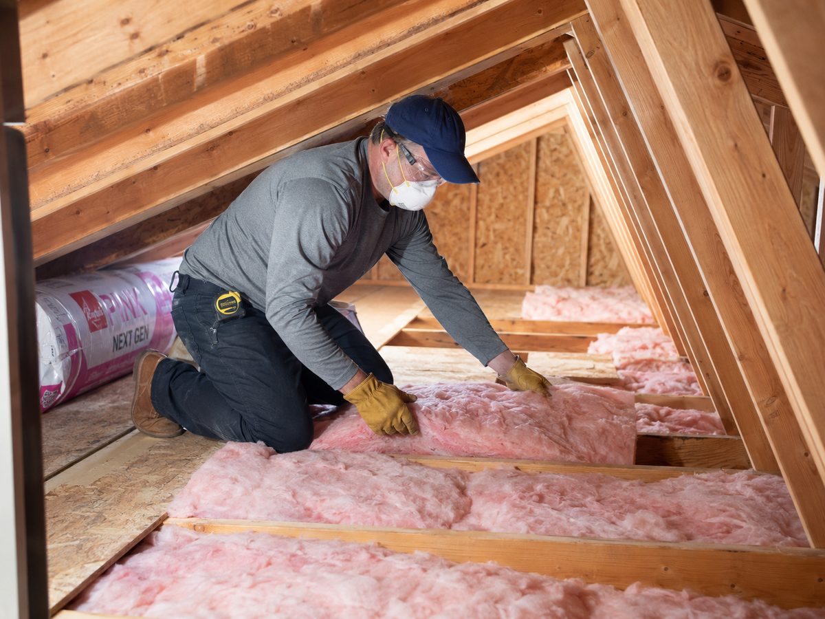 Insulation crew installing blown-in insulation in a Washington home attic